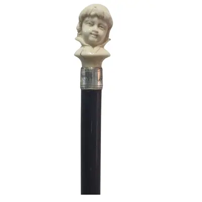 Baston cu capatul sculptat in forma de copil